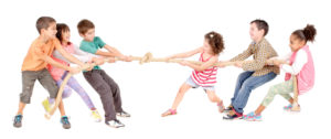 little kids playing pulling rope isolated in white